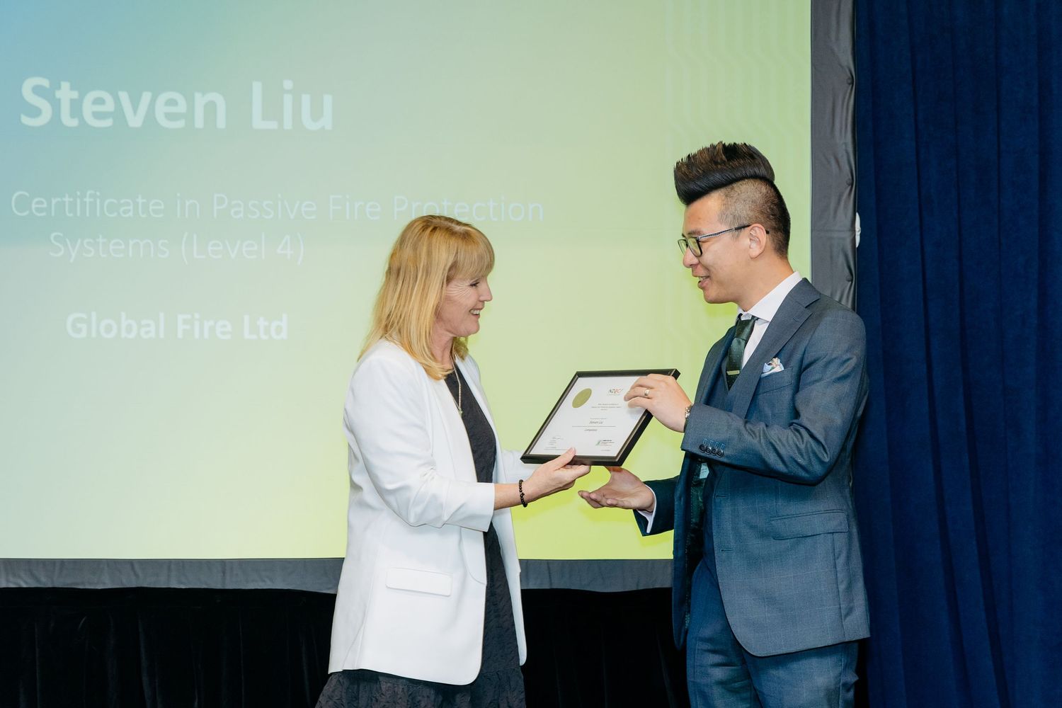 Graduate being presented a certificate on stage at a graduation event