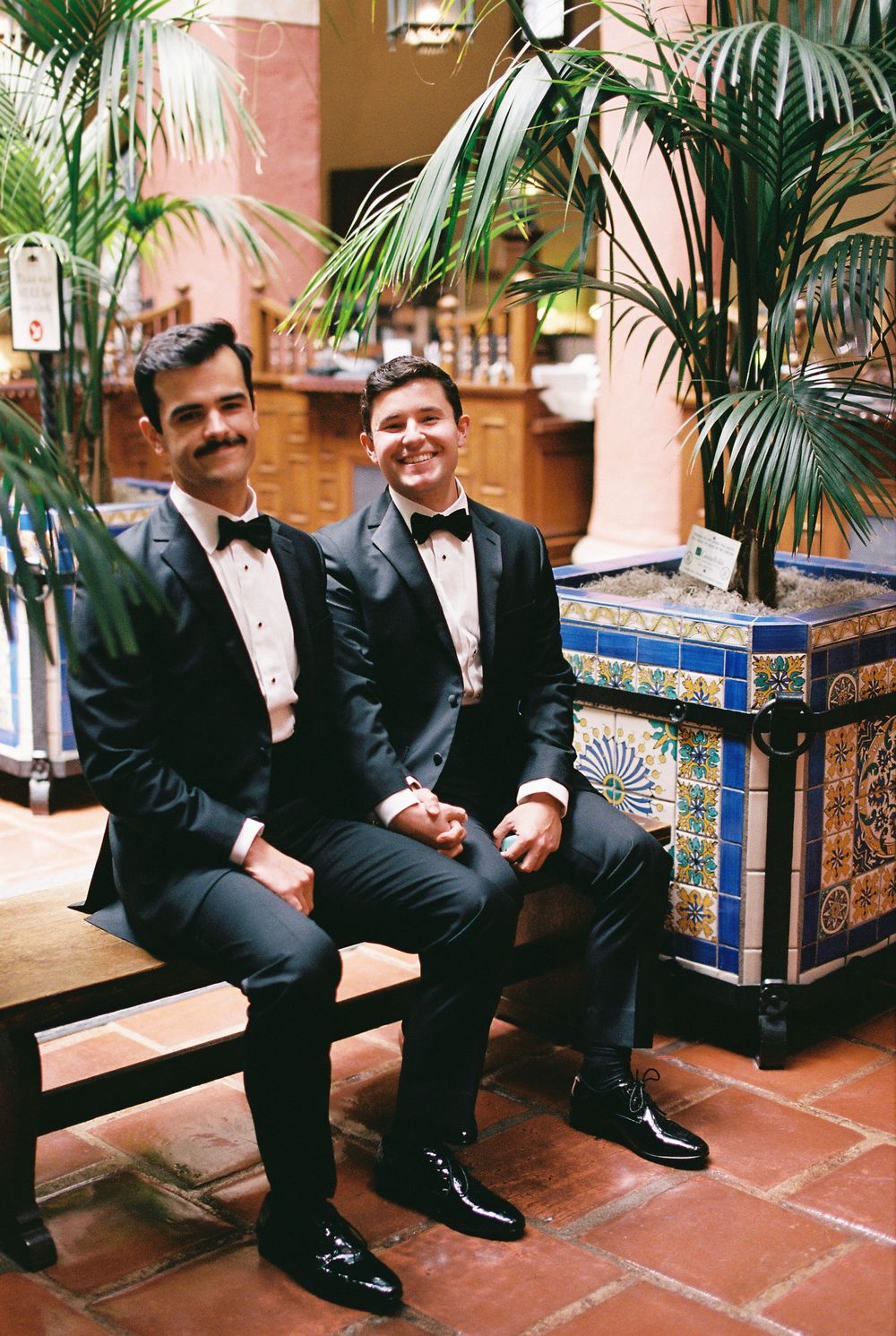 Two grooms laughing together during their civil marriage ceremony at the Santa Barbara Courthouse, captured in a candid, documentary style.
