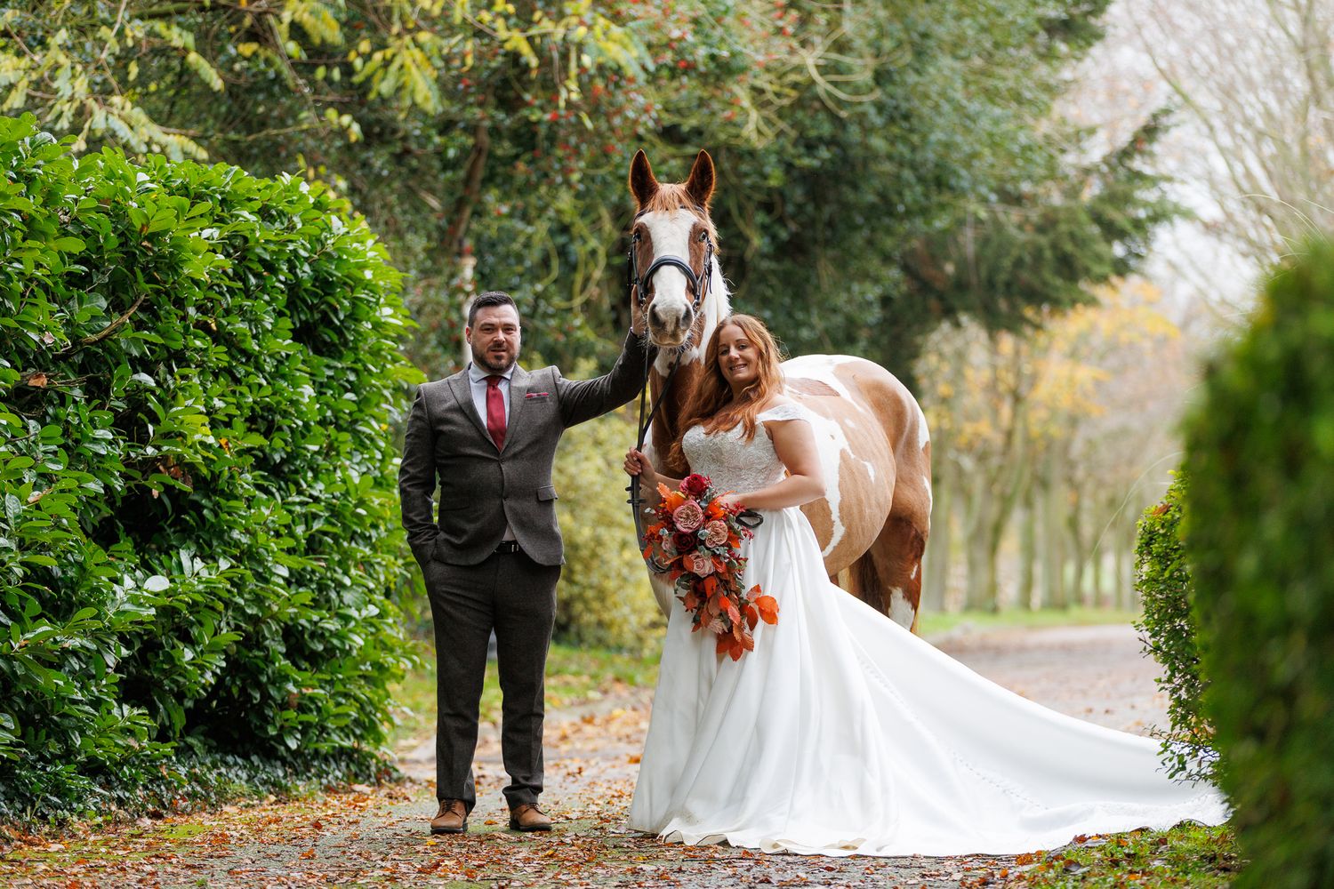 A horse and its rider enjoy an outdoor photoshoot session near rustic wooden fencing on a sunny day.