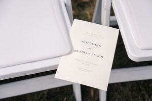 White place cards and seating arrangements displayed on a clean surface at an event.