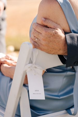 Close-up shots of hands holding white paper wedding ceremony programs.