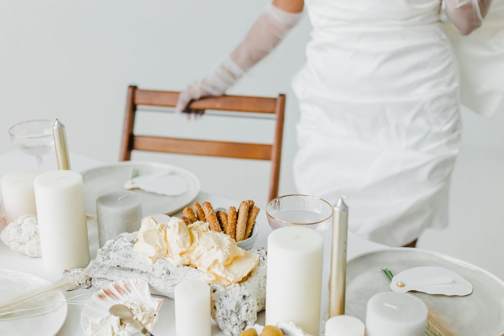 A white table setting with milk glasses and desserts decorated with pecans and whipped cream.