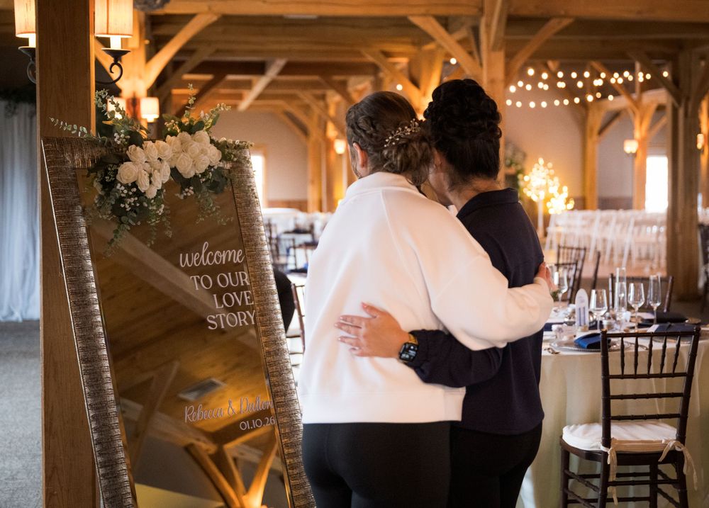 Wedding reception in a rustic barn venue with string lights and wooden beams.