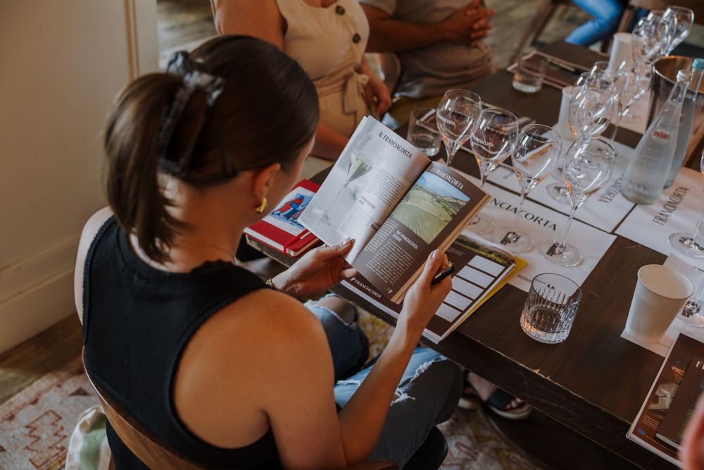 Wine tasting setup with glasses and tasting notes on a wooden table.