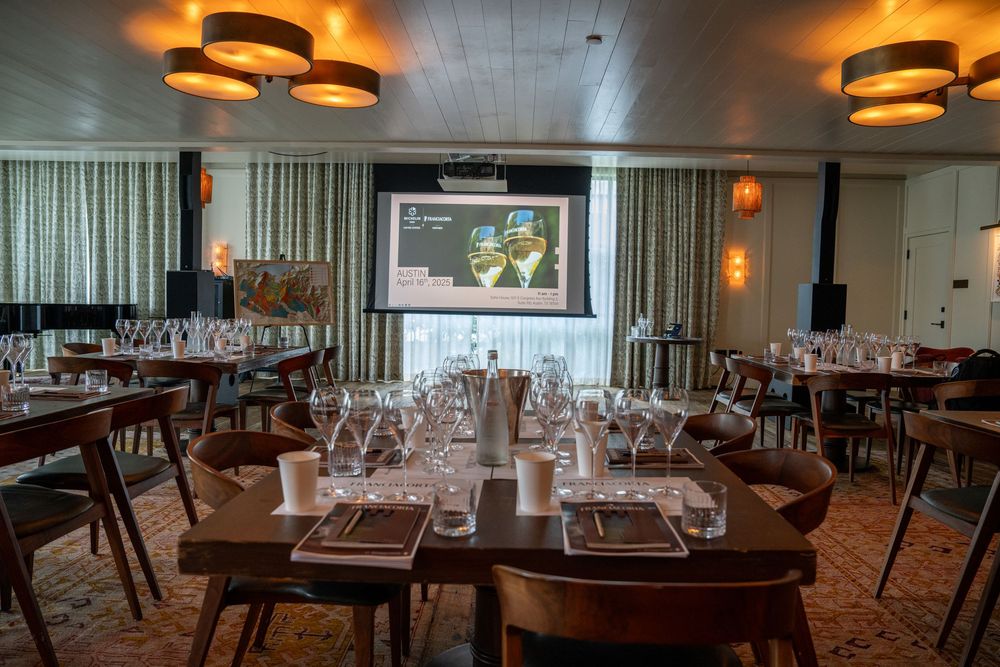 Restaurant dining room with projection screen and formal table settings.