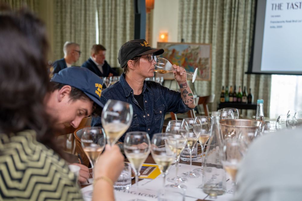 Wine tasting event with multiple glasses set on long dining table.