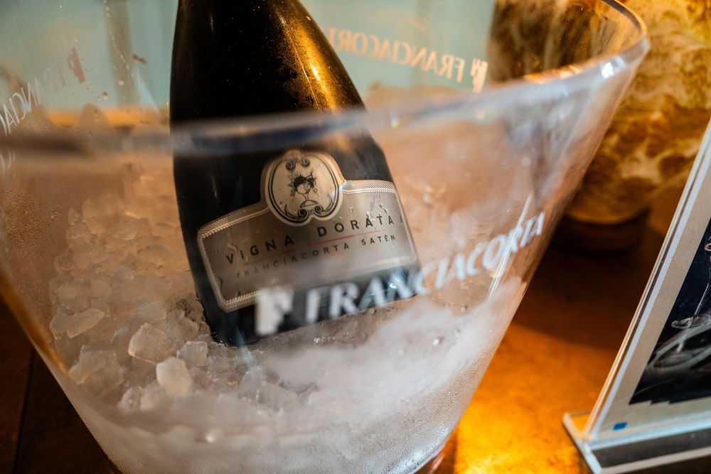 Wine bottle chilling in ice bucket with branded label visible.