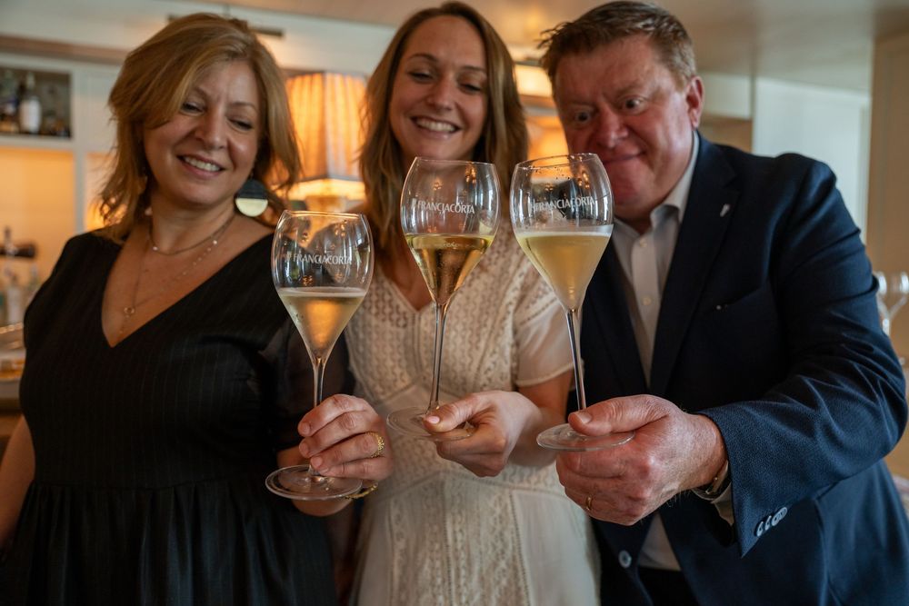 People raising wine glasses in a celebratory toast at an upscale venue.