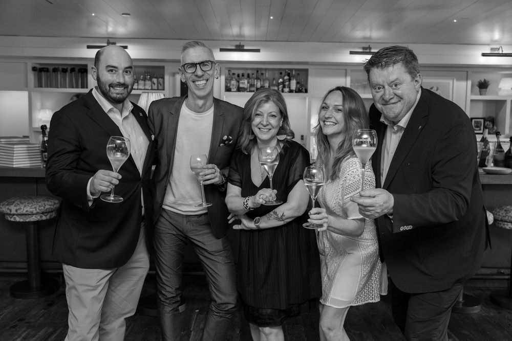 Black and white photo of guests socializing at an indoor gathering.
