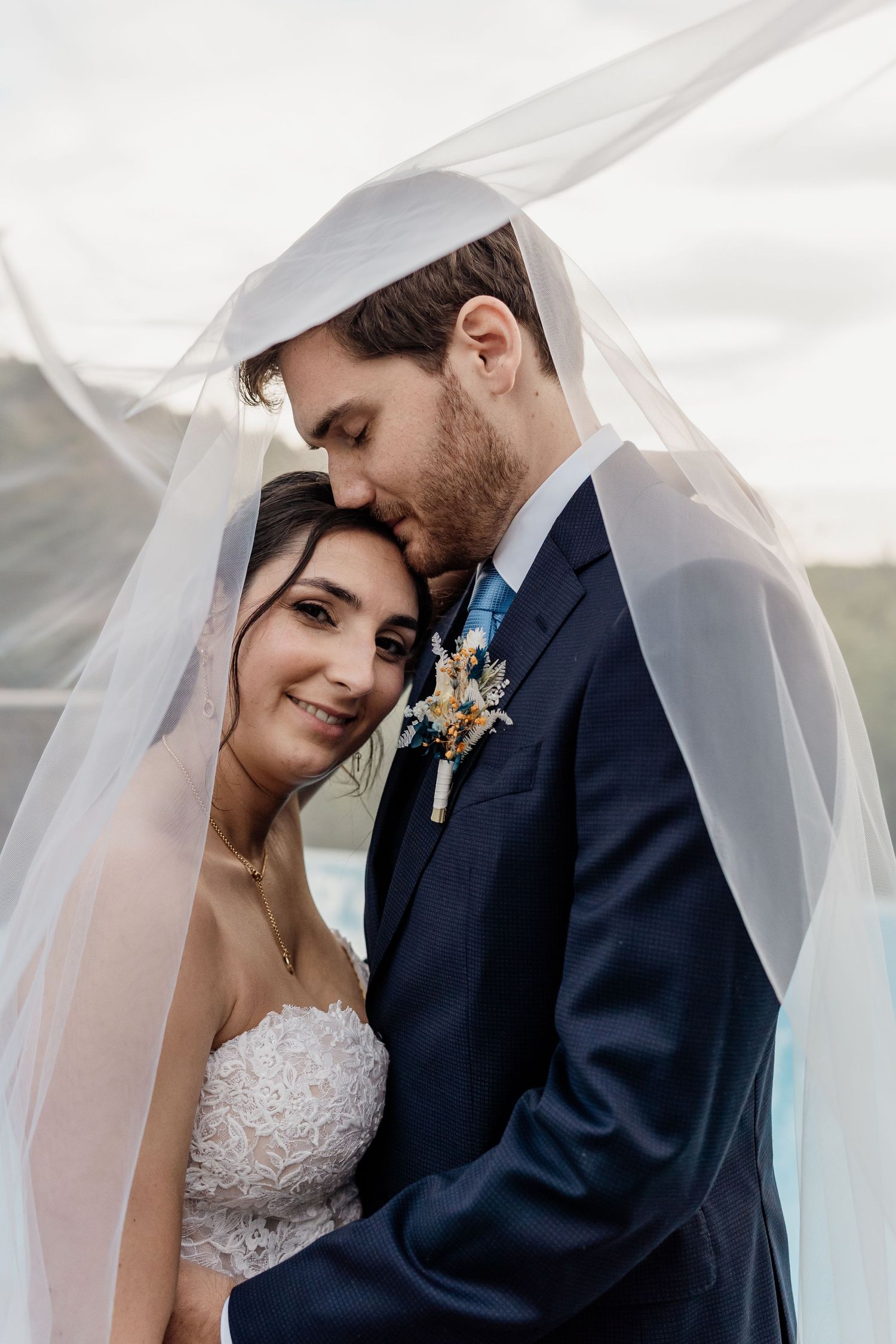 Romantic wedding portrait sequence showing couple sharing intimate moments under flowing white veil.