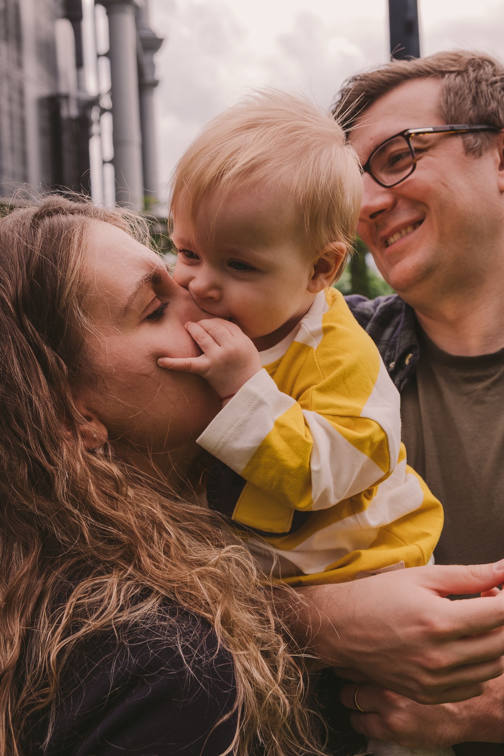 Tender family interactions photographed in warm, candid style outdoors.
