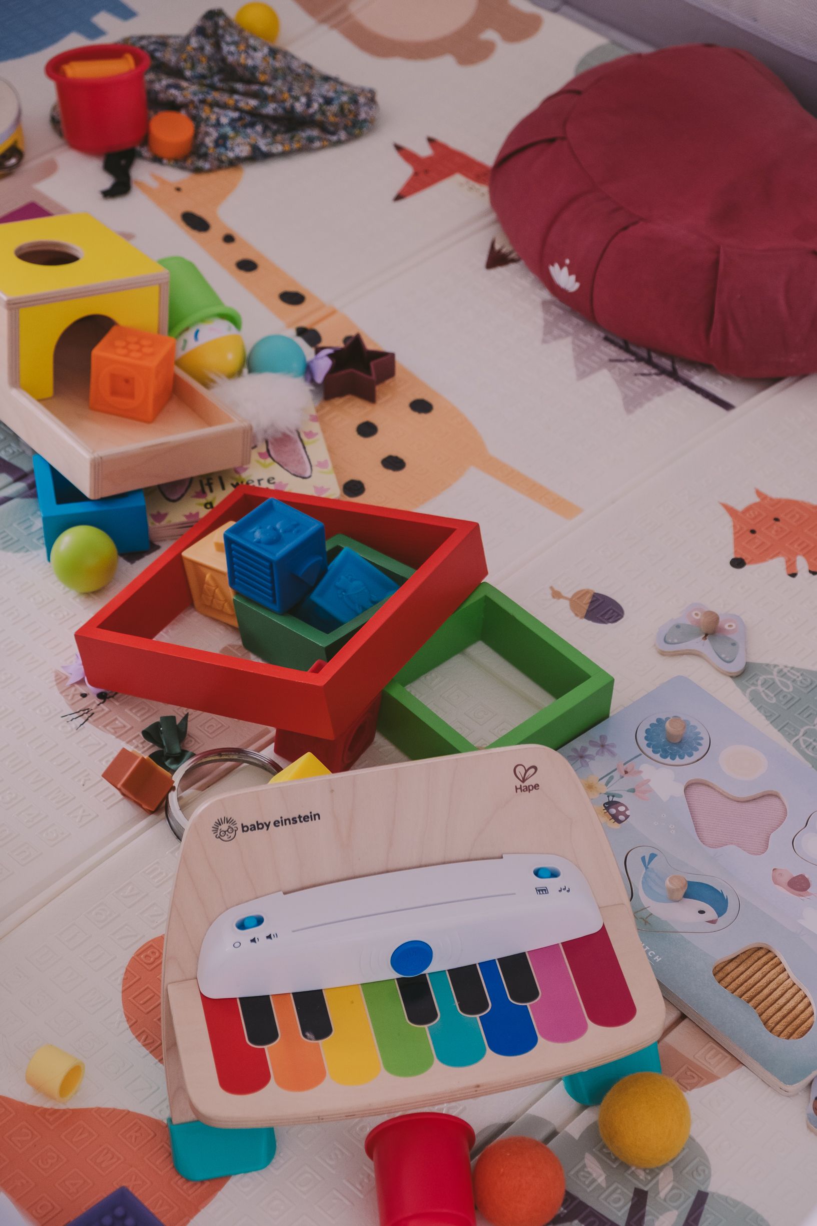 Colorful educational toys and musical instruments scattered on a white surface with artistic drawings and shapes.