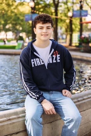 Series of casual outdoor portraits showing someone sitting on concrete steps wearing a navy hoodie and light jeans.
