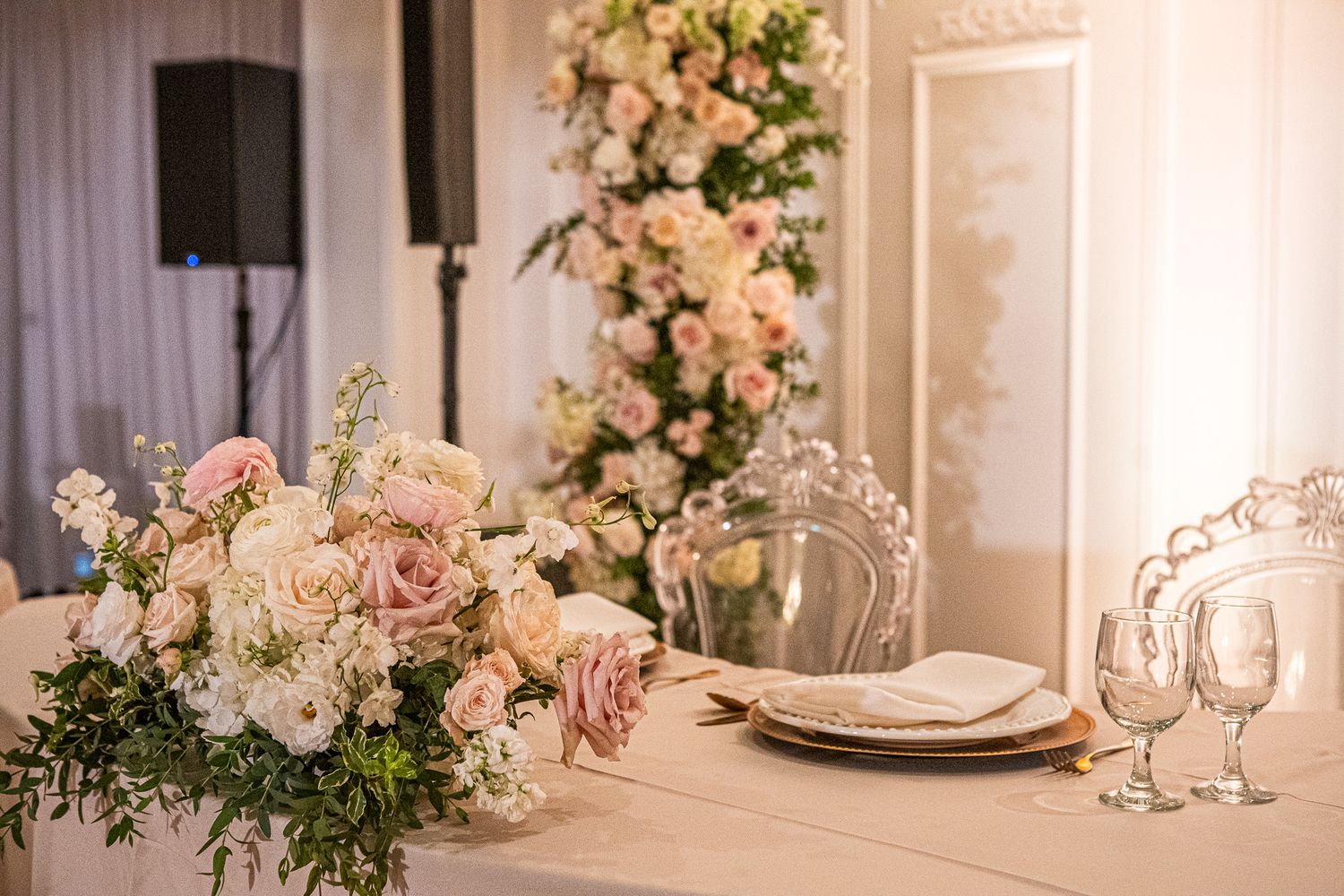 Elegant wedding reception table setting with pink and white floral centerpieces.