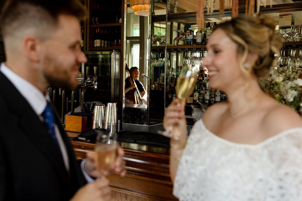 A couple shares a romantic moment while enjoying drinks at an elegant bar setting.