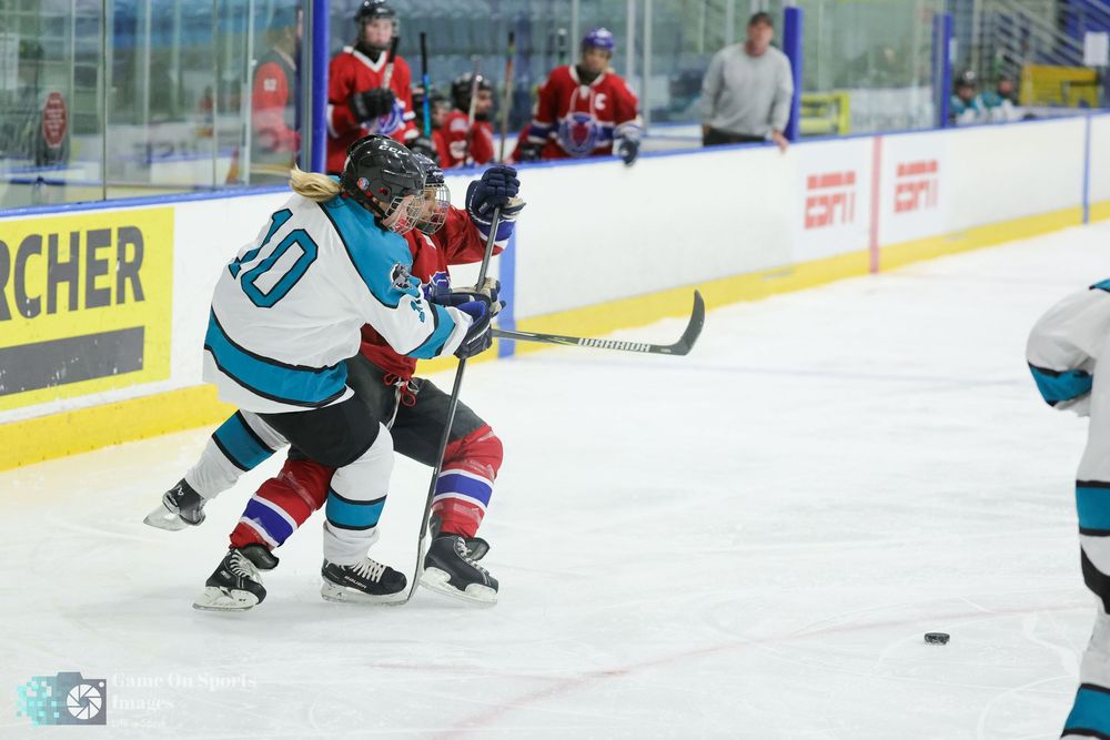 Hockey players battle for control of the puck during an intense ice hockey match.