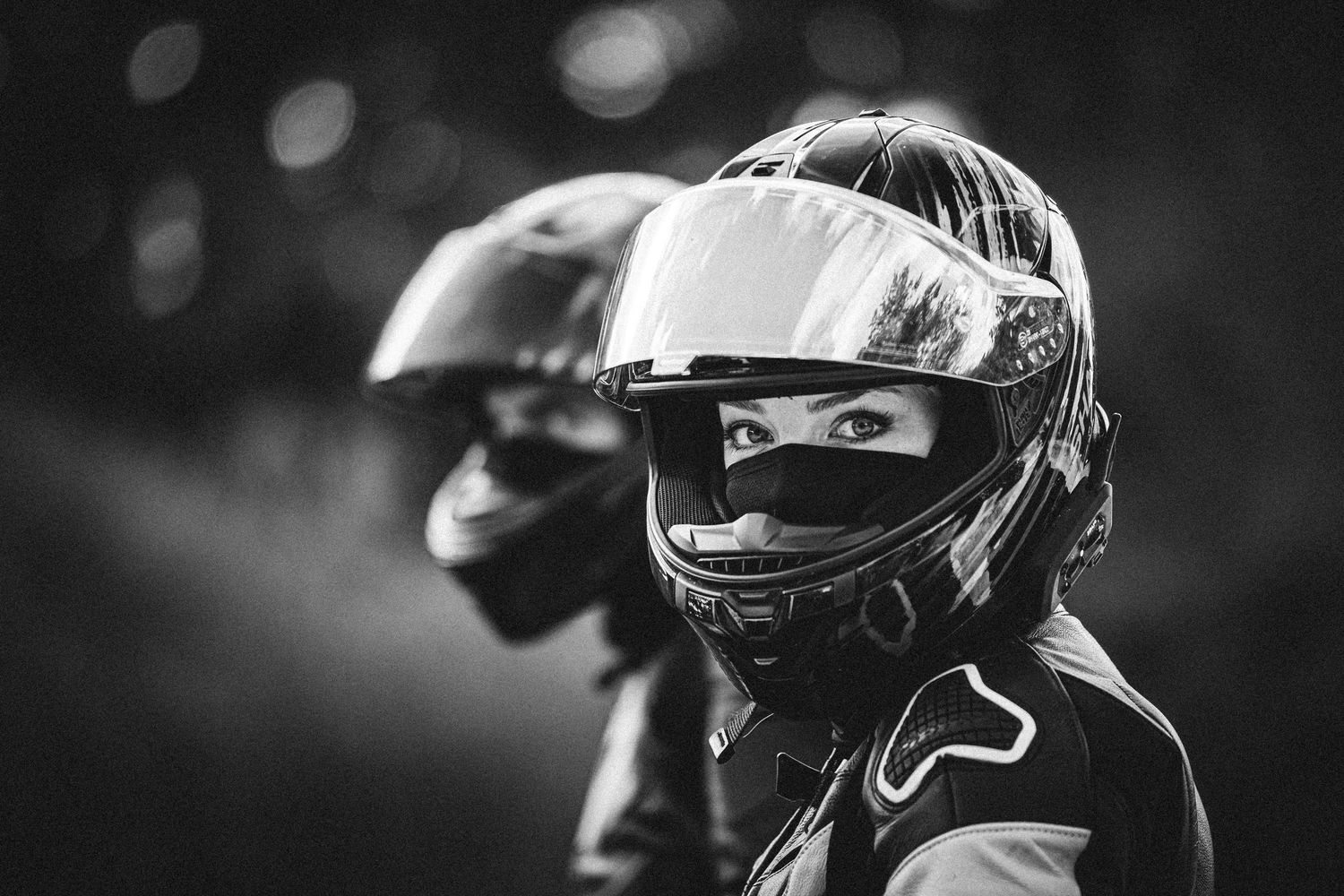 Black and white image of motorsport participants in racing gear.