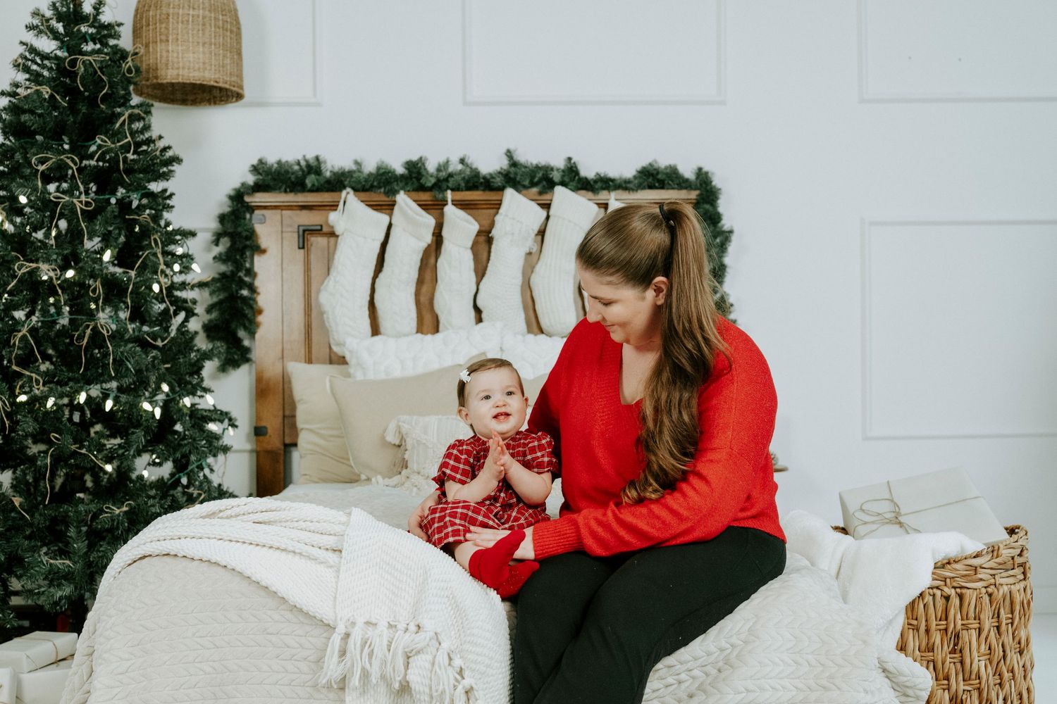 A cozy holiday scene with red and white decor, a Christmas tree, and festive throw pillows on a plush sofa.