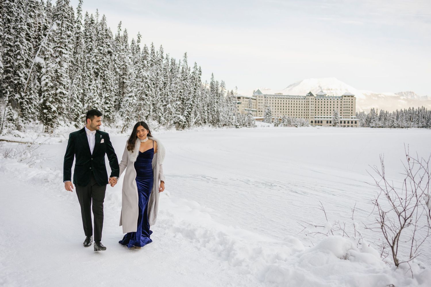 Frozen Lake Louise and Fairmont Chateau Lake Louise winter landscape with couple in foreground