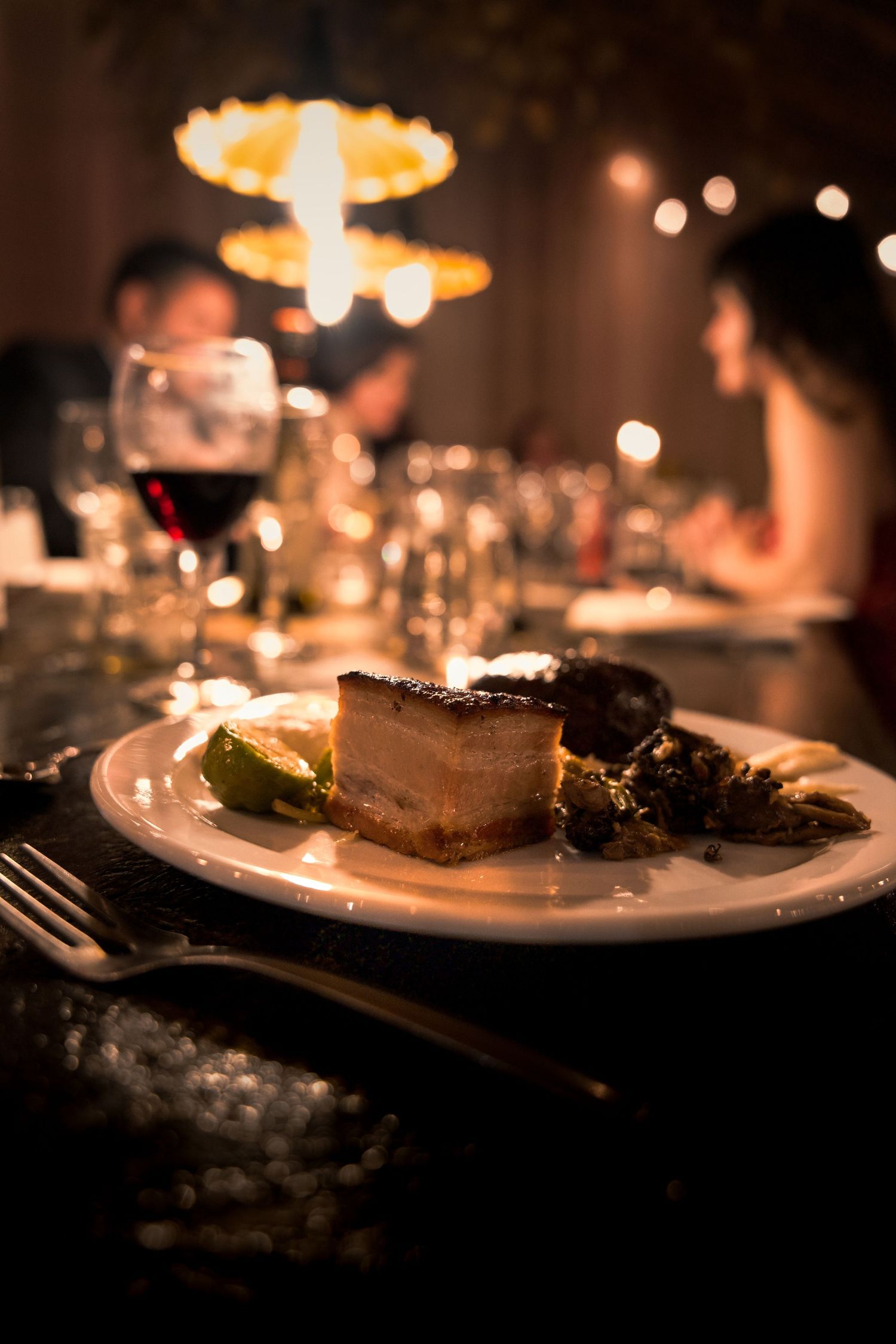 Elegant plated dinner service illuminated by soft ambient lighting at an upscale event.