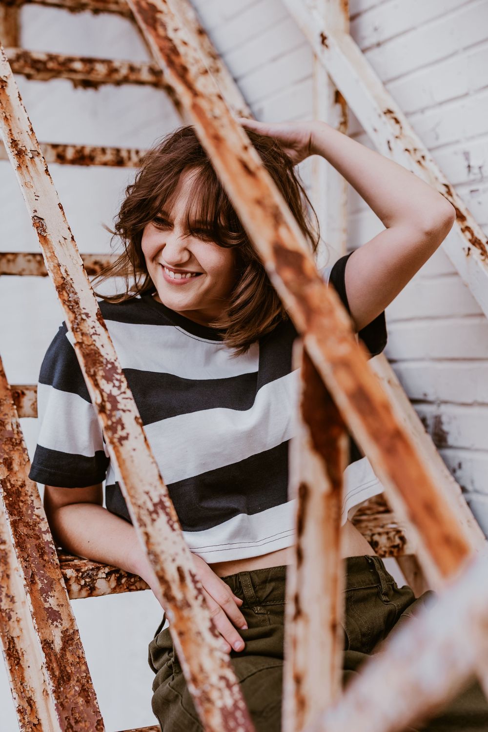 Playful poses captured against rustic white wall background.