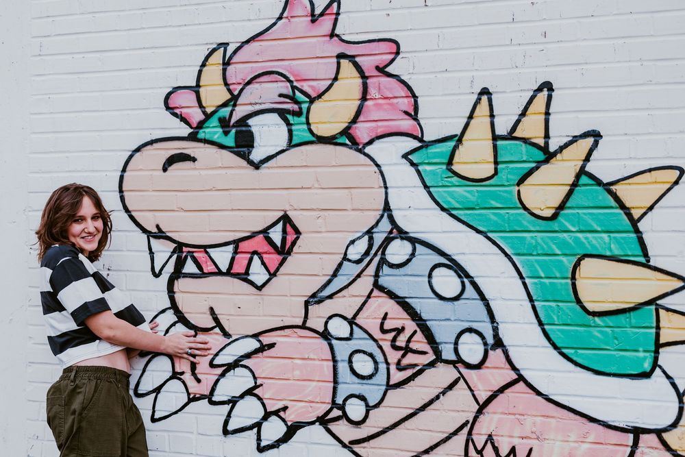 Colorful street art mural featuring cartoon characters on a white wall.