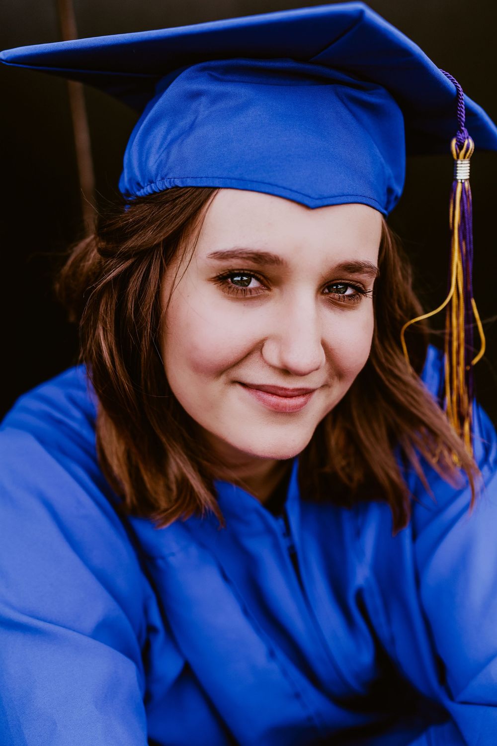 Close-up graduation portraits showing someone in royal blue cap and gown with tassel.