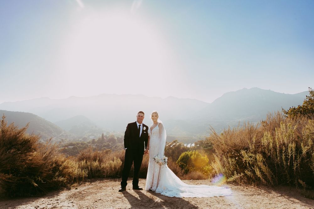 Scenic mountain landscape wedding ceremony photos showing couple and guests against dramatic coastal backdrop.