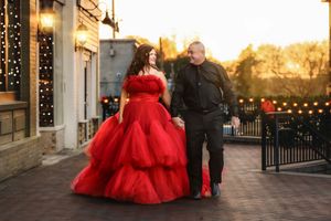 A couple in formal attire walking together in a shopping area that is dressed for Christmas