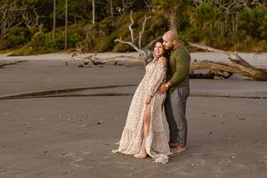 A couple standing on a rocky beach during sunrise