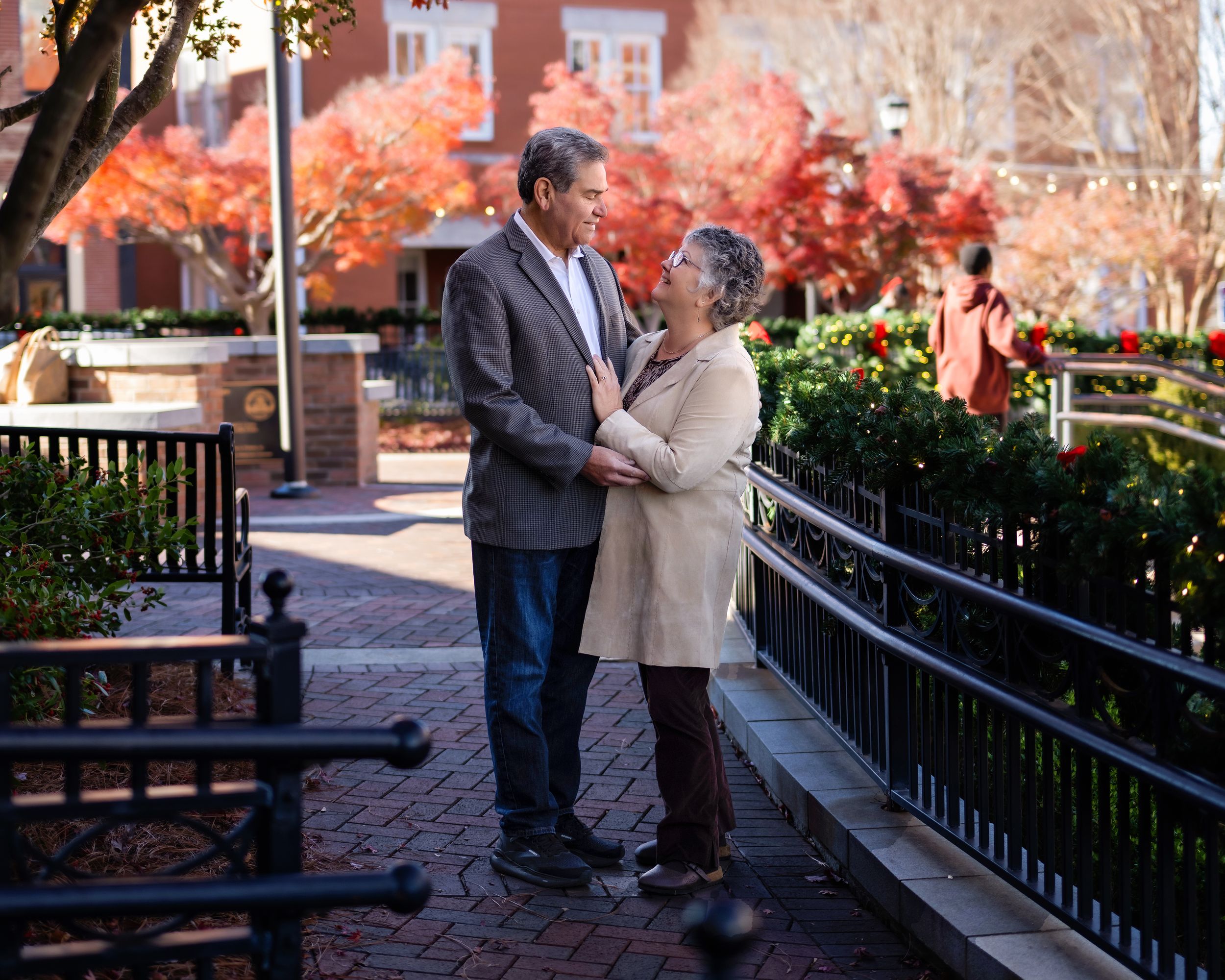 An older couple standing together in a park area downtown