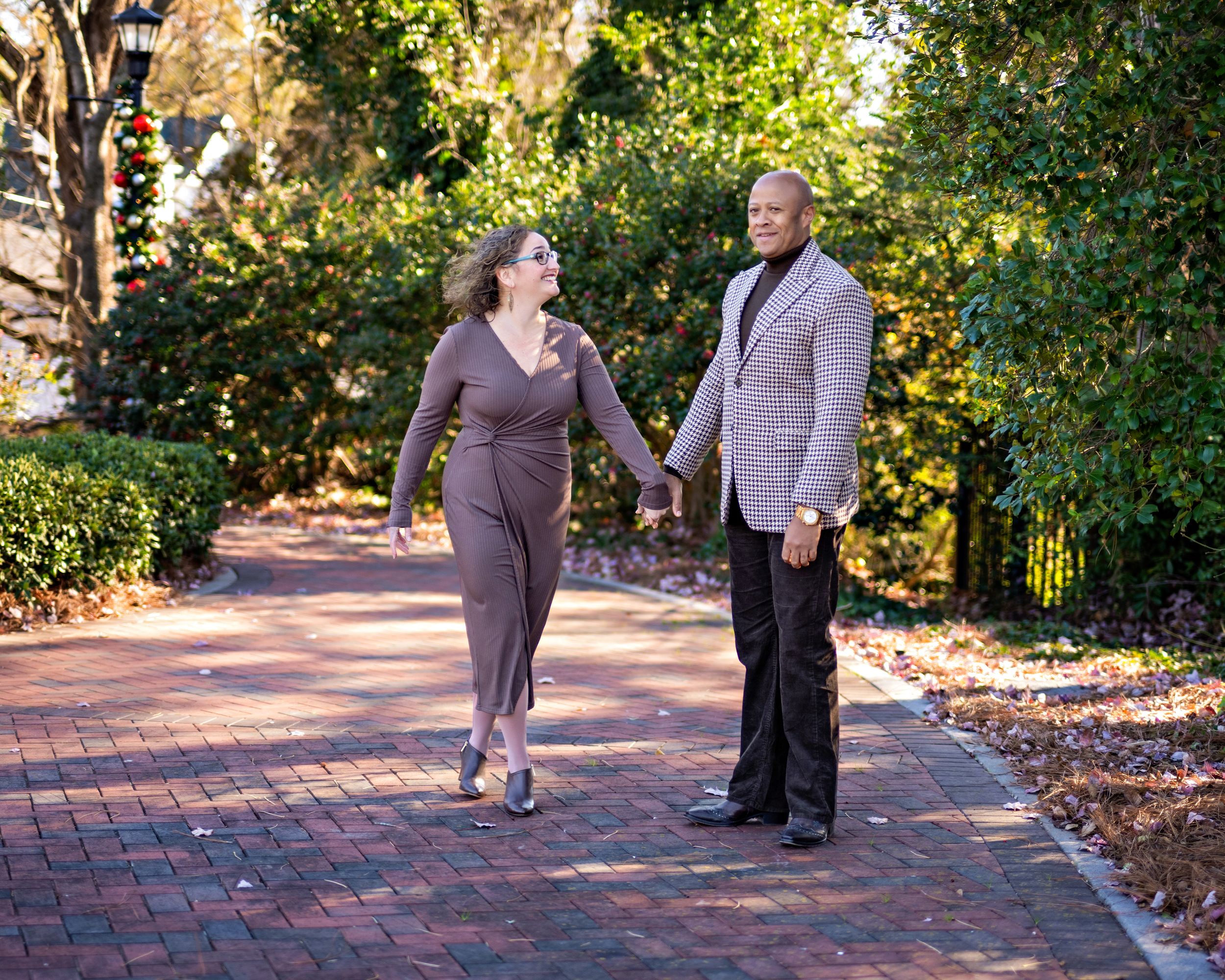 A couple holding hands while walking through the park