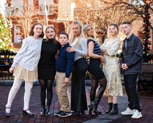 A family of teens standing together in a city park