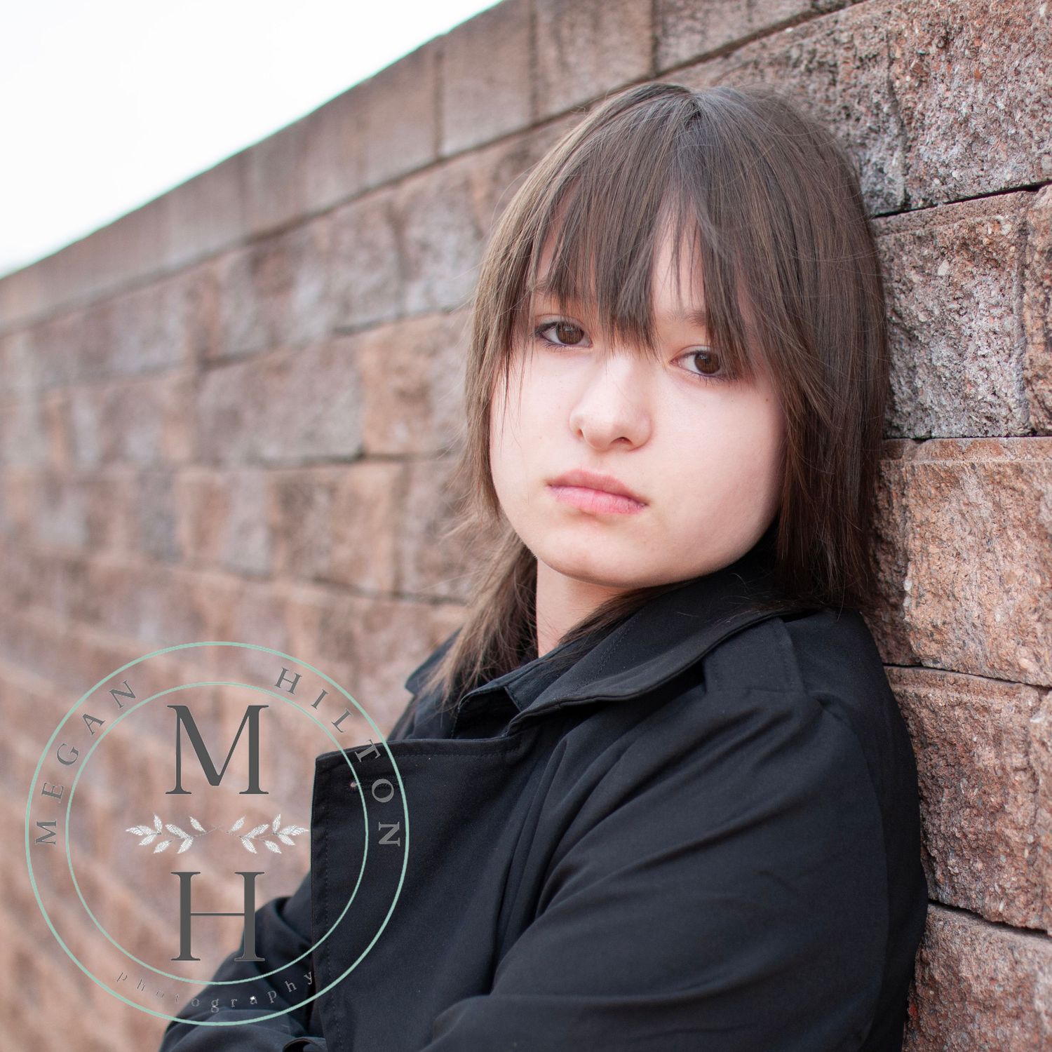 close up high school senior photo against brick wall