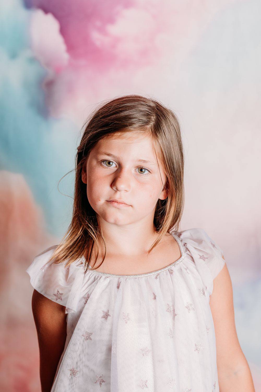 Portrait series showing various expressions against a soft pink and blue watercolor background.