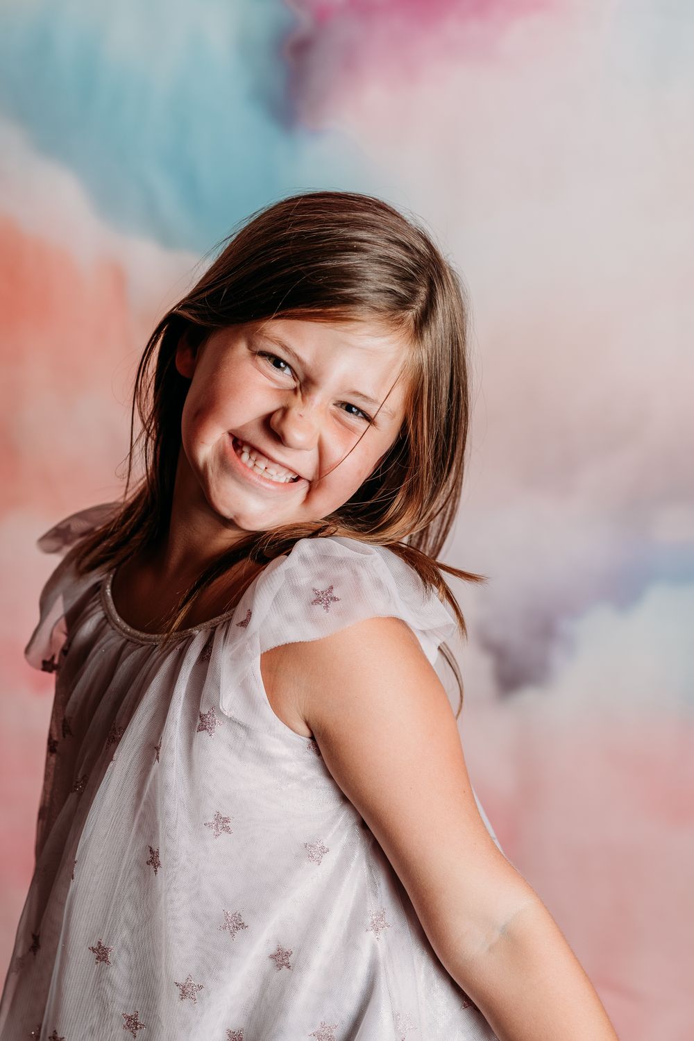A playful photo series against a soft pastel backdrop featuring expressions of joy and movement.