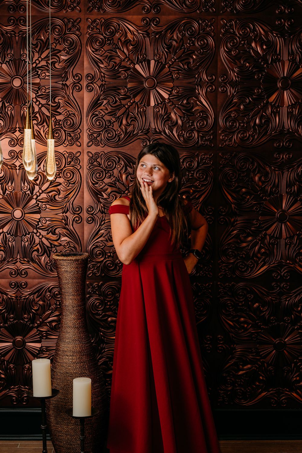 Four artistic portrait photos feature someone in a red dress against an ornate dark wallpaper background with candles.