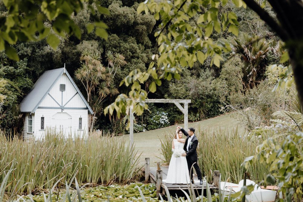 A couple celebrates their wedding on a rustic wooden deck captured by Apertured Media Auckland Wedding Photographer