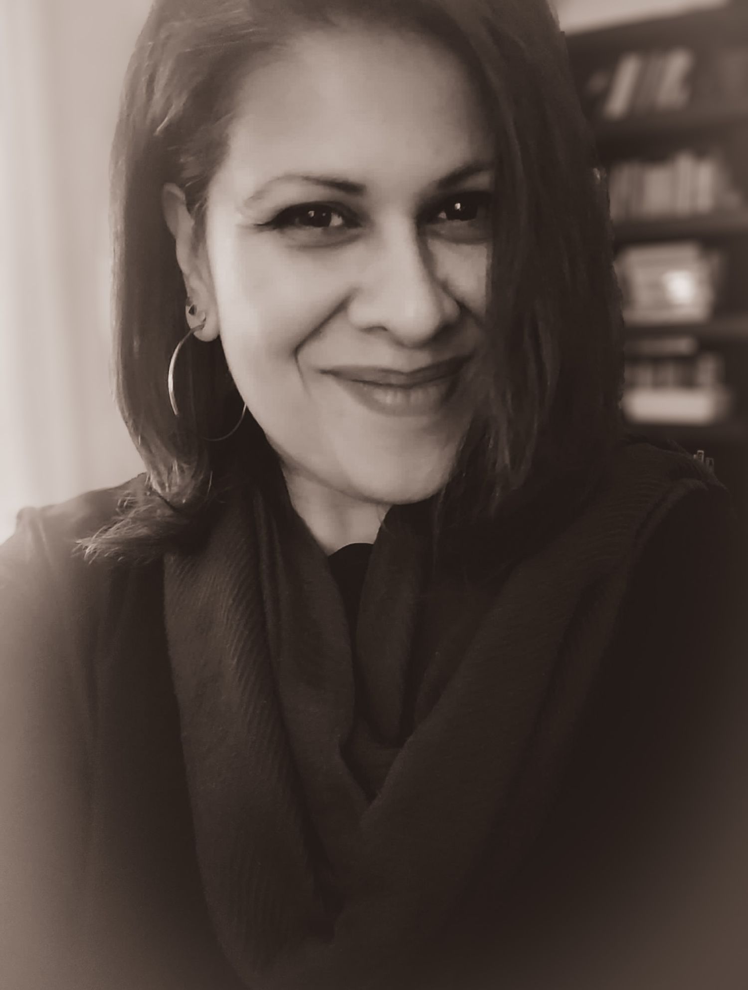 Black and white portrait in soft lighting with dark clothing.