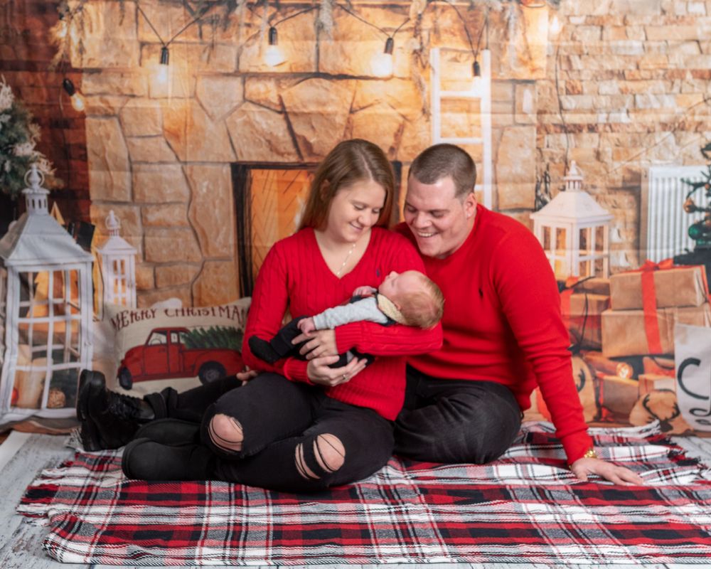 Cozy indoor holiday scene with couple on plaid blanket in brick room with lantern decorations.