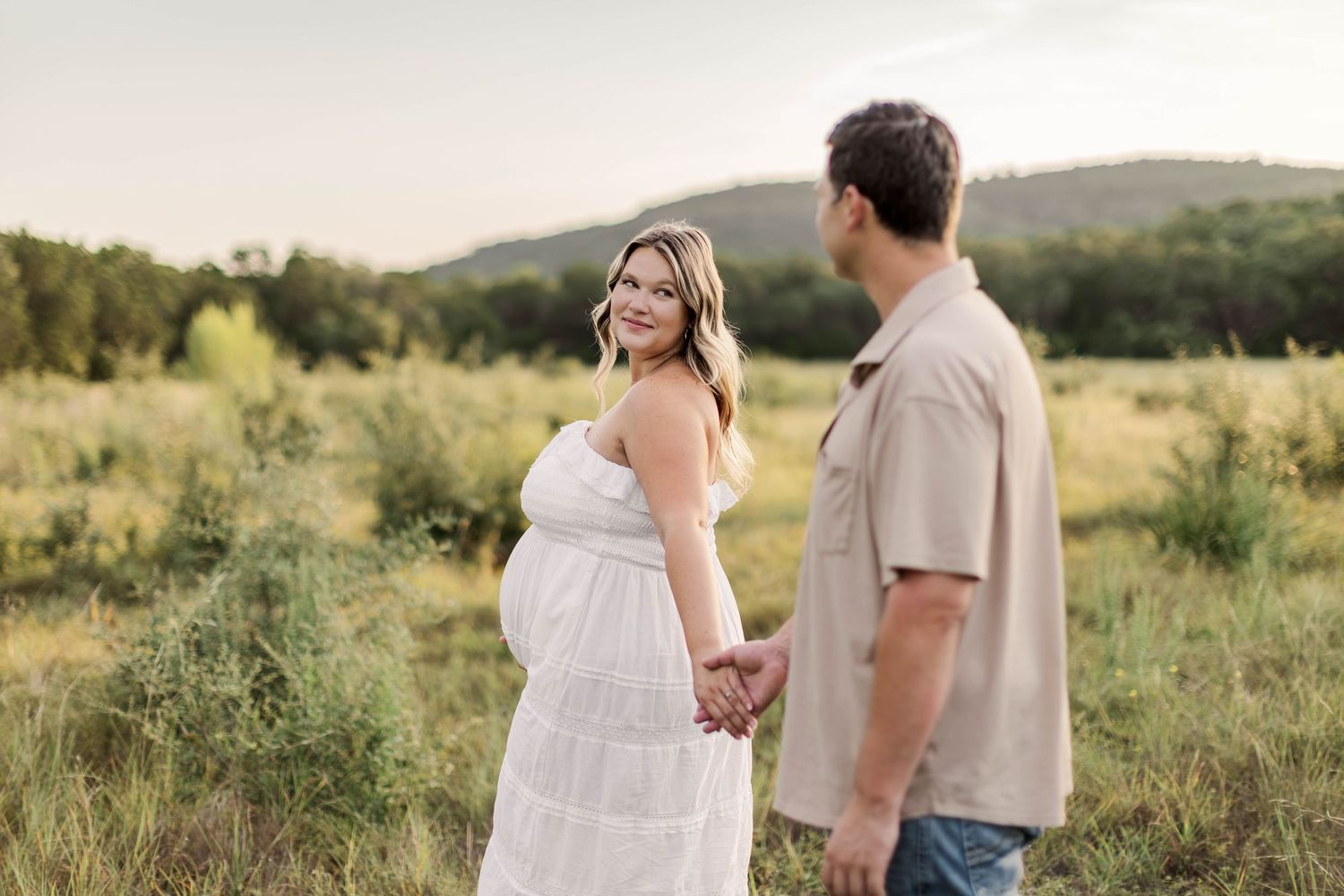 A romantic sunset photoshoot in a golden field captures tender moments between a couple at golden hour, by best San Antonio Photographer.