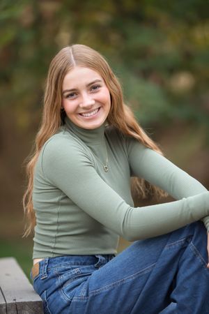 Portrait series featuring someone in a sage green top and jeans against a natural outdoor background.