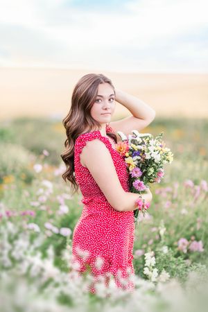 Dreamy meadow scene with red polka dot dress among white and pink wildflowers.