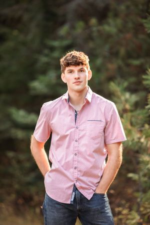 Portrait series showing someone in a pink button-down shirt and jeans in a wooded setting.