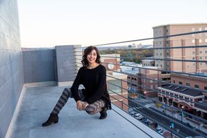 Urban rooftop scene with reflective glass windows and city buildings in the background.