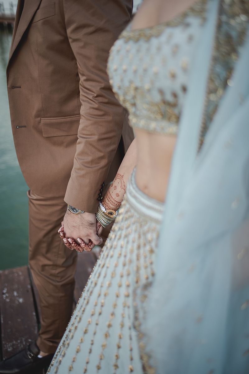 Close-up details of a light blue dress and brown suit at a formal event.
