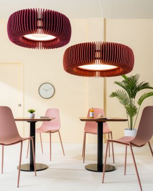 Pink cafe interior with round red pendant lights, bistro tables, and minimalist chairs.