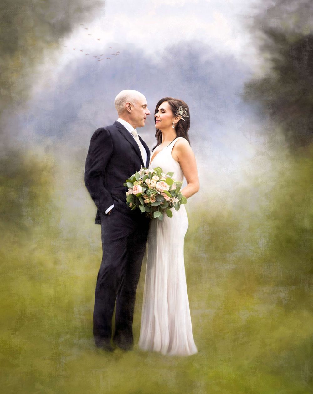 Artistic wedding portrait in soft focus with green and cloudy background.