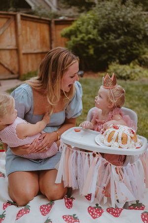 A series of candid photos showing a parent and child sharing a special moment with a birthday cake on a high chair.
