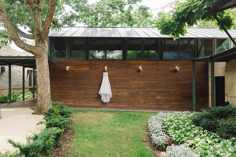 Modern wood-paneled home exterior with green landscaping and decorative stones along a curved pathway.